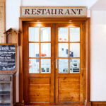 The wooden door restaurant entrance at Hotel La Brunerie, Les Deux Alpes